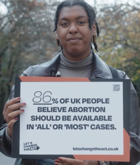 Screenshot from a video of a woman holding a placard that reads 86% of UK people believe abortion should be available in 'all' or 'most' cases